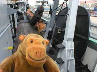 Mr Monkey looking at an otter board on the deck of the Amandine