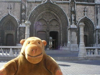 Mr Monkey looking at the front door of St Peter and Paul church