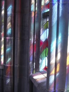 Light shining through stained glass windows onto stonework
