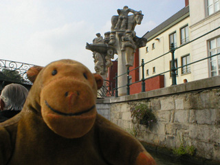 Mr Monkey looking at statues on a bridge