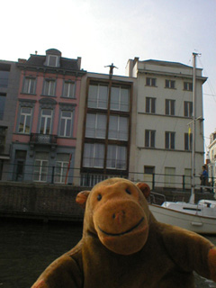 Mr Monkey looking at an apartment block on the west bank of the Leie