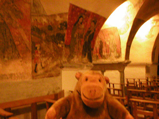 Mr Monkey looking at wall paintings in the crypt