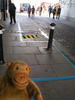 Mr Monkey following the blue line around a pair of bollards under the South Approach