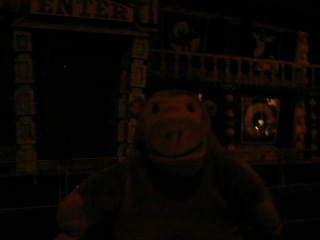 Mr Monkey looking at a haunted house in the dark