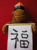 Monkey in mandarin hat holding 'good luck' scroll