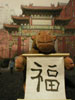 Monkey holding 'good luck' scroll in front of Chinese Arch